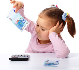 Image showing Little girl with few paper euro banknotes