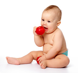 Image showing Little child is going to bite red apple