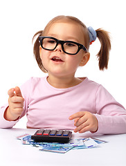 Image showing Little girl plays with money