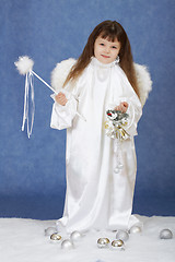 Image showing Little girl in suit of angel on a blue background