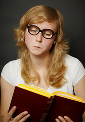 Image showing Woman in funny old-fashioned glasses reading book