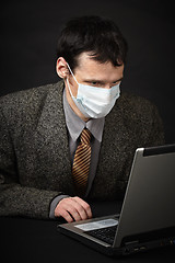 Image showing Man in medical mask diagnoses computer