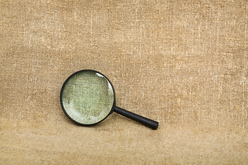 Image showing Old magnifier on brown canvas background