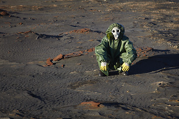 Image showing Man in protective clothing sitting in desert