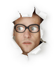 Image showing Funny man in an old-fashioned glasses looking out of hole