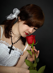 Image showing Beautiful girl smells red rose