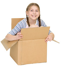 Image showing Amusing little girl sits in cardboard box isolated on white back