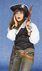 Image showing Scared woman - sea pirate on blue background with pistol