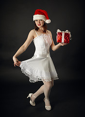 Image showing Woman in Christmas cap with a celebratory gift