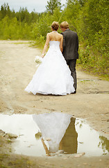 Image showing Newly-married couple walks on rural road