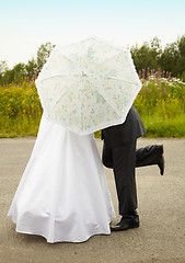 Image showing Couple kissing behind an umbrella