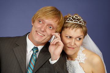 Image showing Groom calls on a cell phone, bride overhears