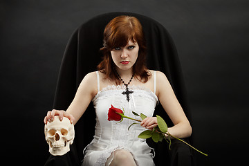 Image showing Beautiful girl sitting in chair with skull and rose