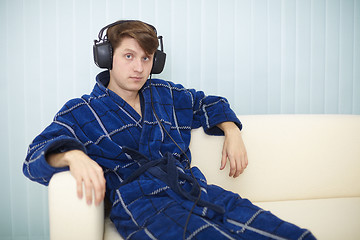 Image showing Man in dark blue dressing gown listens to music