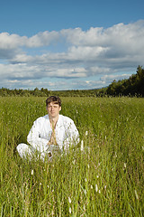 Image showing Young man meditates in a field