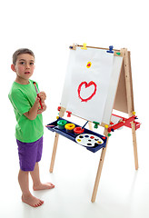 Image showing Young child standing at art easel