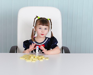 Image showing Little amusing girl is playing with toys