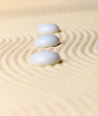 Image showing Composition three white stones on yellow sand - Zen Garden