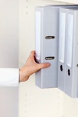 Image showing Hand clerk takes archival documents