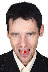 Image showing Young man eats a pill put it on tongue