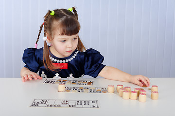 Image showing Little girl playing with lotto sitting at table