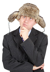 Image showing Young man in a fur hat dreams on white background