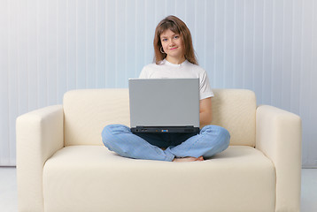 Image showing Girl sitting on couch with a laptop
