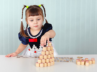 Image showing Little girl builds tower of lotto