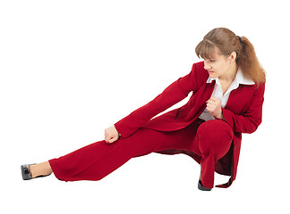 Image showing Woman in red business suit kicks