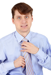 Image showing One young man arranges his tie on white