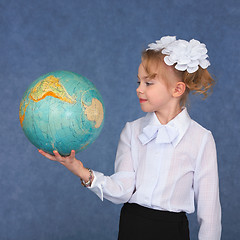 Image showing Schoolgirl looking at a geographical globe