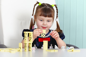 Image showing Child playing with dominoes at table