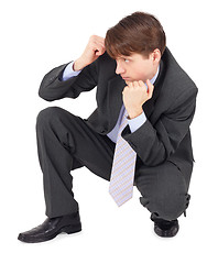 Image showing Young man sits in a defensive pose on white