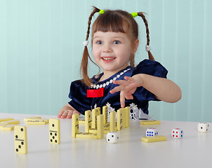 Image showing Cheerful child playing with small toys at table