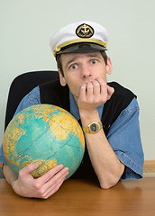 Image showing Seaman misses on distant travel sitting at table with globe