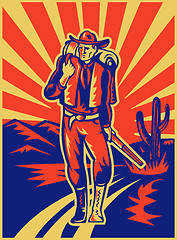 Image showing Cowboy carrying backpack and rifle