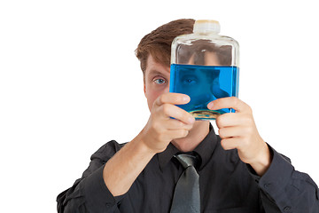 Image showing Man checks physical properties of liquid in bottle