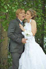 Image showing Amusing groom and bride kiss secretly