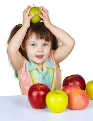 Image showing Little girl plays with fruit - apples