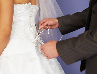 Image showing Groom unties corset to bride