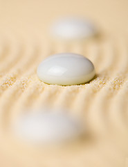 Image showing White pebbles on yellow sand closeup