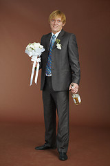 Image showing Groom with bouquet and bottle of sparkling wine