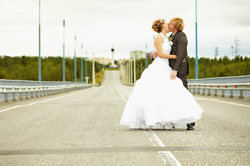 Image showing Newlyweds kissing passionately on highway