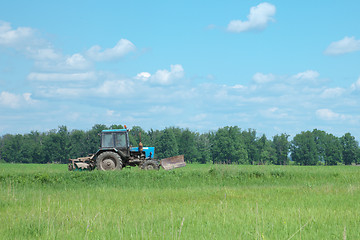 Image showing Old tractor goes through field