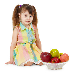 Image showing Little girl and dish filled with apples