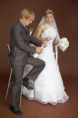 Image showing Amusing bride scaredly waits for popping champagne