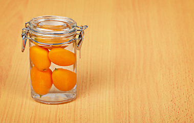 Image showing Kumquat inside a glass jar on wooden background