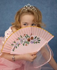 Image showing Girl hides behind her fan