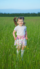 Image showing Happy child jumps on green grass in field
