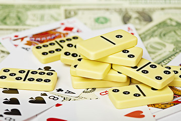 Image showing Handful of dominoes on cards and money